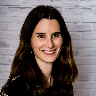 Lächelnde Frau vor Ziegelwand