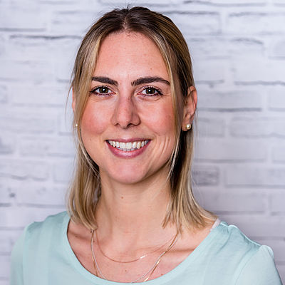 Lächelnde Frau vor Ziegelwand